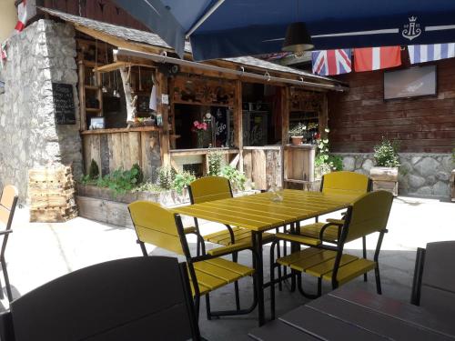 a wooden table and chairs in front of a restaurant at Daeli Hotel in Mestia