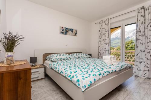 a bedroom with a bed and a window at Apartments Marija in Baška