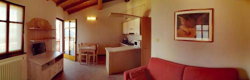 uma sala de estar com um sofá vermelho e uma cozinha em Residenza Cristina em Brenzone sul Garda