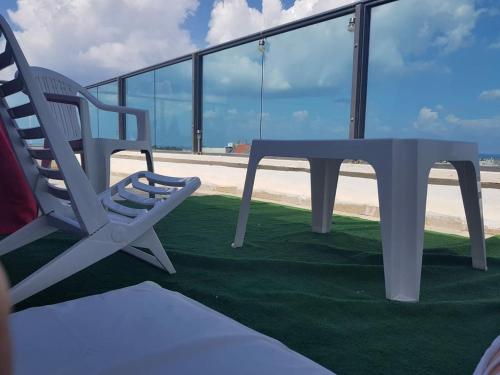 a table and a chair sitting on a balcony at comft suite Nahariyya in Nahariyya