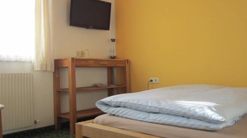 a bedroom with a bed and a tv on the wall at Ramseiderhof in Saalfelden am Steinernen Meer