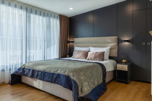 a bedroom with a large bed with black walls at Norah Suites Hotel İstanbul in Istanbul