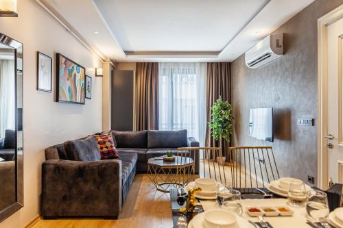 Norah Suites Hotel İstanbul في إسطنبول: غرفة معيشة مع أريكة وطاولة