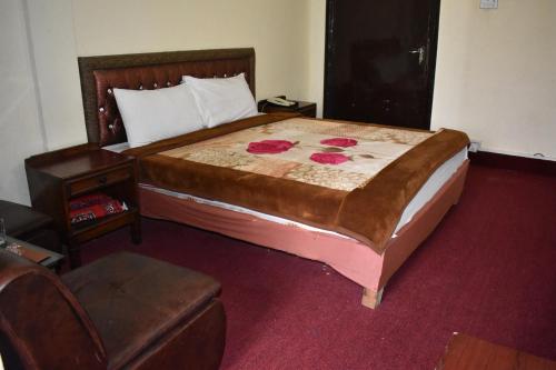 a bedroom with a large bed and a chair at Hotel Islamabad Residency in Islamabad