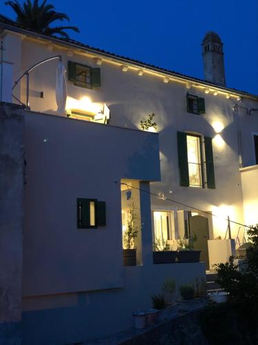 a white house with lights on the side of it at Casa Rustica in Mali Lošinj