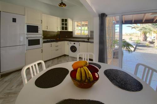 a kitchen with a table with a basket of fruit on it at Finca Arbequina in Pájara