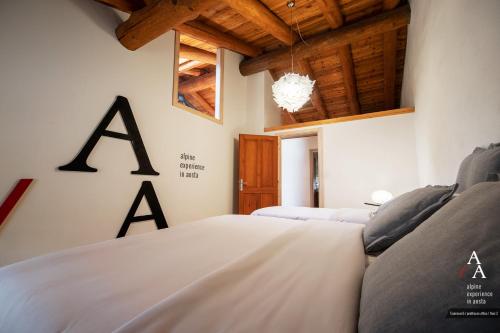 a bedroom with two white beds and wooden ceilings at Alp Apartments SKI & BIKE - Tourneuve5 in Aosta