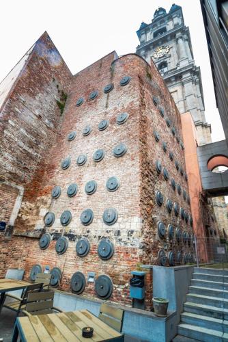 a brick building with a clock tower in the background at Auberge de Jeunesse de Mons in Mons