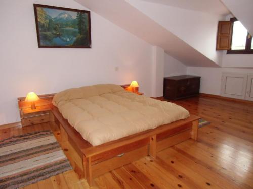 Bielva的住宿－Bielva Céntrico con Vistas，铺有木地板的客房内的一张大床
