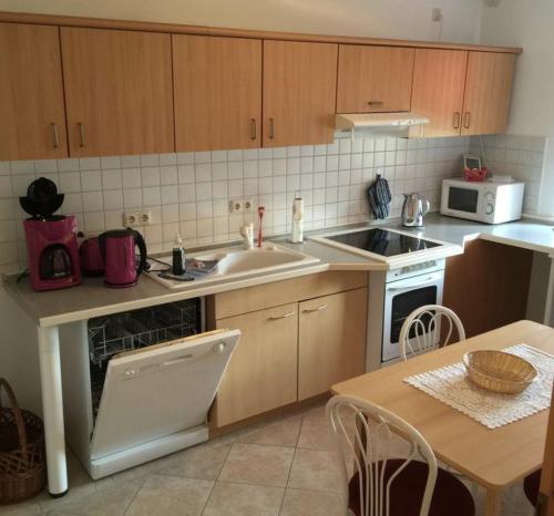 a kitchen with a sink and a stove top oven at Hotel garni SEESCHLÖSSCHEN in Kolpinsee