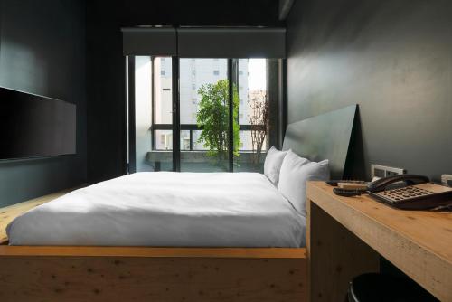 a bedroom with a bed and a window at SOF Hotel in Taichung