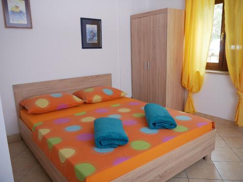 sypialnia z łóżkiem z 2 niebieskimi poduszkami w obiekcie Apartment Gaga and Nia w Krku
