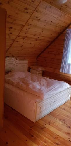 a bedroom with a bed in a wooden attic at Two Floors House on Chernomorskaya in Bolʼshaya Balabanka
