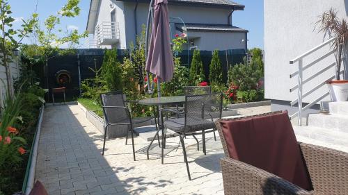 a patio with a table and chairs and an umbrella at VillaGrey Tunari in Tunari
