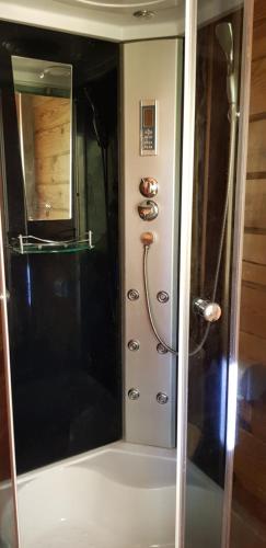 a shower with a glass door in a bathroom at Two Floors House on Chernomorskaya in Bolʼshaya Balabanka