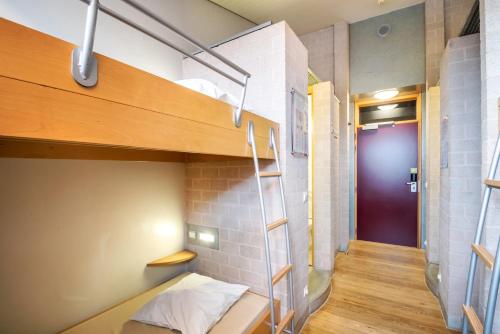 a small room with a bunk bed and a purple door at Auberge de Jeunesse de Mons in Mons