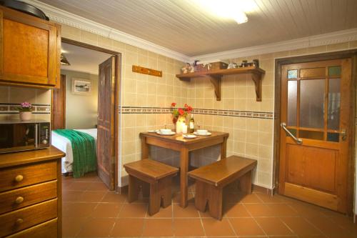 a kitchen with a small table and benches in it at Togryersvlei Venue & Guest House in Jacobs Bay