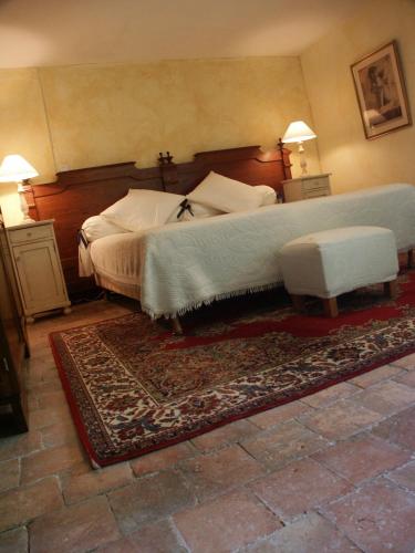 une chambre avec un grand lit et un tapis dans l'établissement Chateau de Vareilles, à Sommant