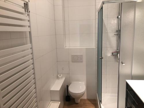 a white bathroom with a toilet and a shower at Apartament w centrum in Kościerzyna