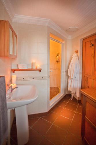 a bathroom with a sink and a shower with candles at Togryersvlei Venue & Guest House in Jacobs Bay
