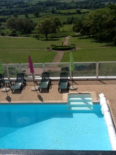 une piscine avec chaises et parasols à côté d'une clôture dans l'établissement Chateau de Vareilles, à Sommant