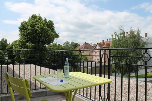 a yellow table and chairs on a balcony at Villa Élyane in Colmar