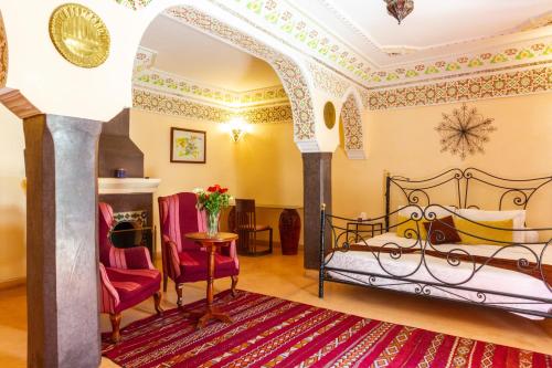 a bedroom with a bed and a table and chairs at Riad le dromadaire bleu by Weekome in Marrakesh
