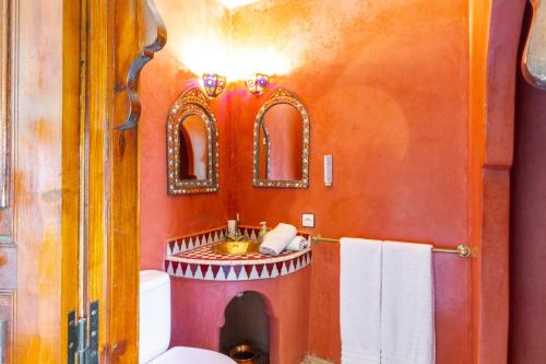 a bathroom with a toilet and a sink and mirrors at Riad le dromadaire bleu by Weekome in Marrakesh