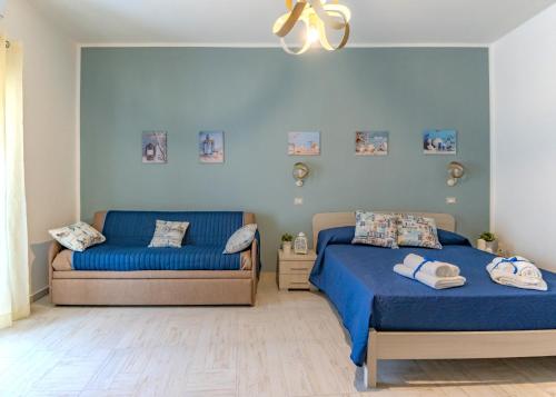two beds in a bedroom with blue walls at Bebcatia in Agropoli