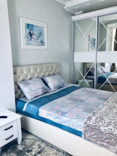 sypialnia z łóżkiem i lustrem w obiekcie White apartments in Arcadia w Odessie
