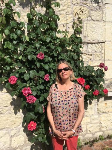 kobieta stojąca przed rośliną z różami w obiekcie chambre sur jardin entre Fontevraud et RignyUssé w mieście Avoine