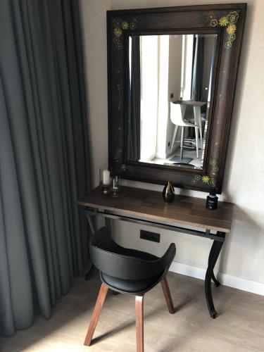 Un escritorio con un espejo y una silla en una habitación. en Butas centre, en Klaipėda
