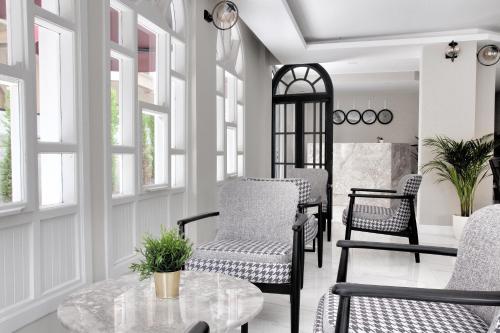 a living room with chairs and a table and windows at Siete Hotel in Antalya
