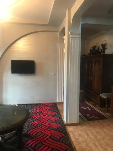 a living room with a table and a tv on a wall at Apartment on Grishashvili 1 in Batumi