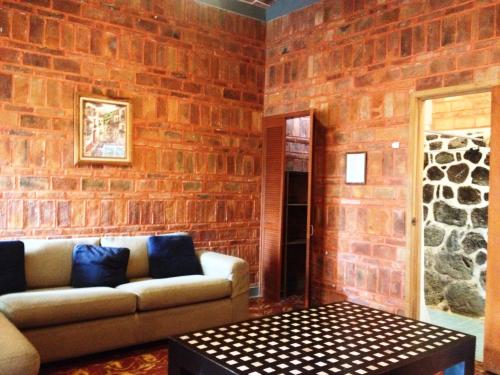 a living room with a couch and a brick wall at Mama Chuy Hotel & Villas Ajijic in San Juan Cosalá