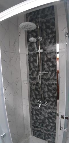 y baño con ducha y pared de pescado. en Moonlight Apart Hotel en Dalyan