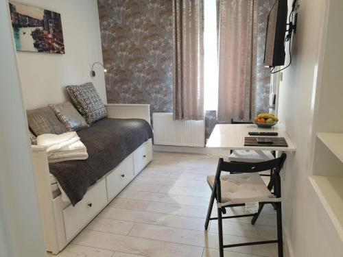 een slaapkamer met een bed en een bureau en een tafel met een stoel bij Sweet Suites Residence in Lytham St Annes