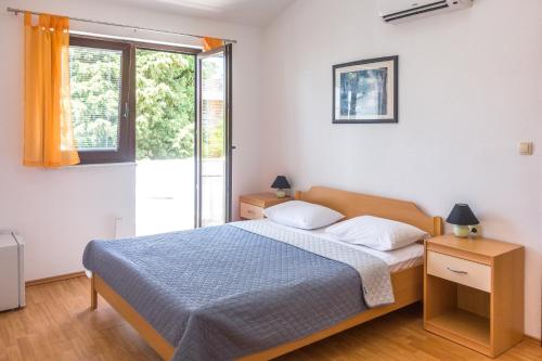 Schlafzimmer mit einem Bett und einem Fenster in der Unterkunft Rooms Stolfa in Krk