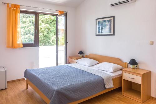 sypialnia z łóżkiem i oknem w obiekcie Rooms Stolfa w Krku