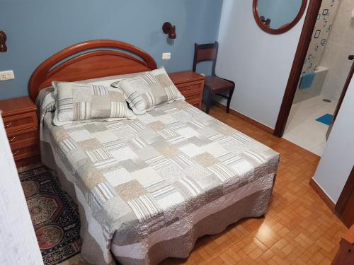 um quarto com uma cama e uma cabeceira em madeira em Rincón Do Demo em Nigrán