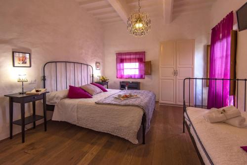 a bedroom with two beds and a chandelier at B&B Country House Poggio Del Drago in Ponticino