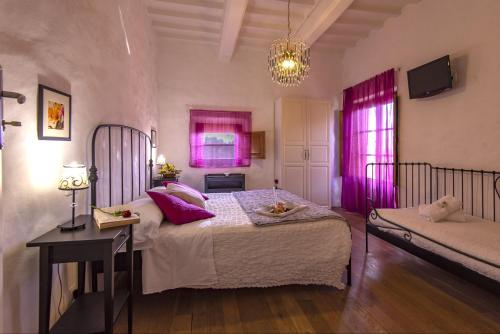 a bedroom with a large bed with pink curtains at B&B Country House Poggio Del Drago in Ponticino
