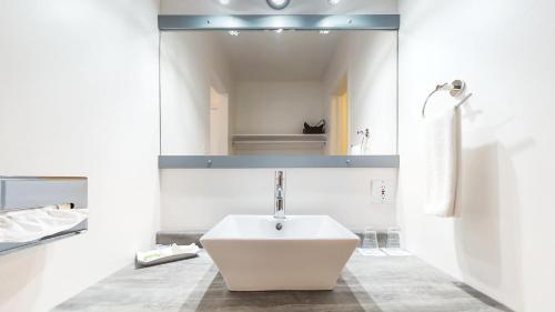 a bathroom with a white sink and a mirror at Riotel Bonaventure in Bonaventure