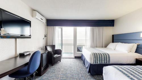 Habitación de hotel con 2 camas y escritorio en Riotel Bonaventure en Bonaventure