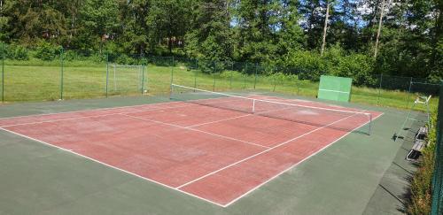 a tennis court with a net on top of it at Stuga på Hallandsåsen in Hjärnarp