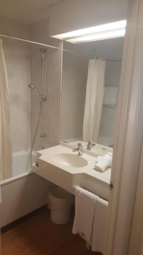 a bathroom with a sink and a mirror at Novotel Firenze Nord Aeroporto in Sesto Fiorentino