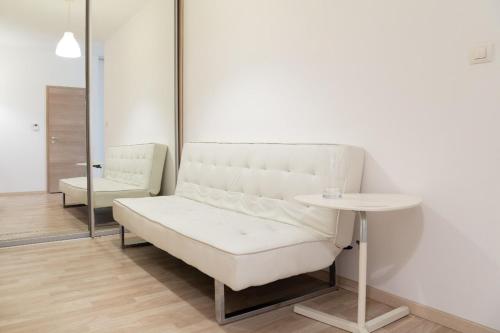 a white bench in a room with a table at Great tourist and business Apartment near center in Bratislava