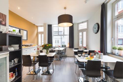 een keuken en eetkamer met tafels en stoelen bij B&B De Hofnar Roermond in Roermond