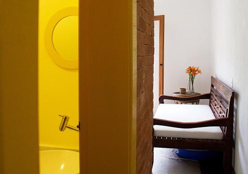 a bathroom with a tub and a bench in a room at Estalagem Camburi in Camburi