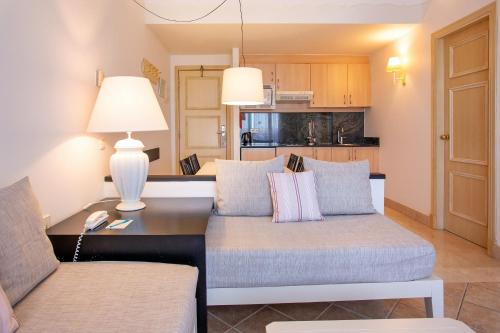 a living room with a couch and a table at Grupotel Macarella Suites & Spa in Son Xoriguer